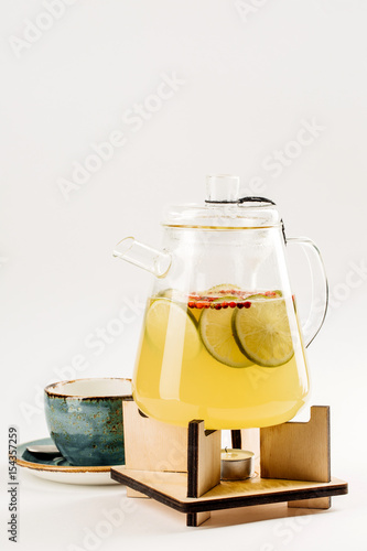 Healthy fruit  tea in glass kettle is heated candle tablet