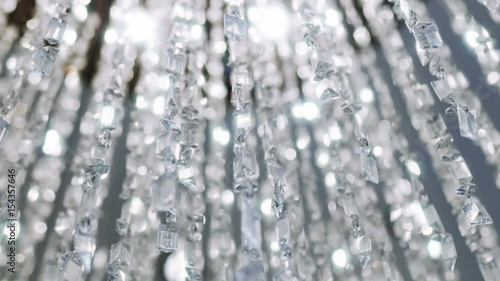 Crystal chandelier. Big classic crystals. 
Low angle shot of a big beautiful crystal luxury chandelier. With bling bling shining reflection.
