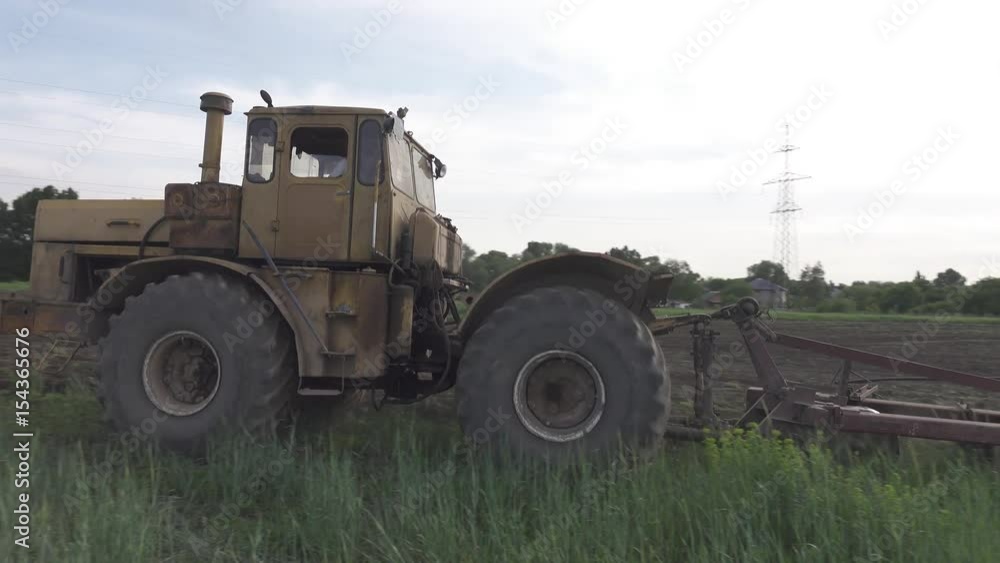 The tractor begins to plow the field. 4k. Flat pikture profile The tractor begins to plow the field. 4k. Flat pikture profile