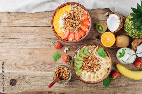 Granola with Greek yoghurt and fruit on a wooden background in a rustic style