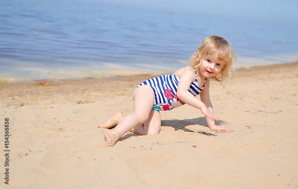 Little girl playing at the beach in sunny day Little girl playing at the beach in sunny day