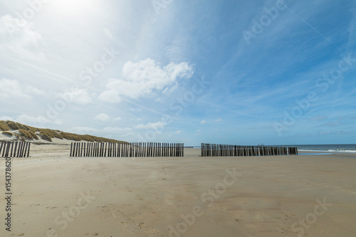 Lonesome Beach Of North Sea With Timber Piles In The Background - Netherlands