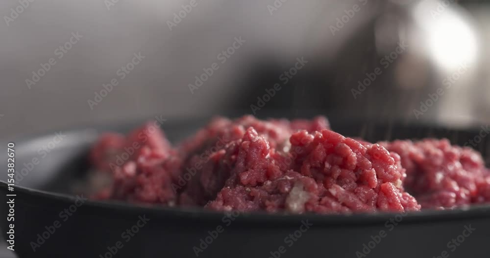 Slide shot of adding pepper on roasting minced beef in a pan, 4k 60fps prores footage Slide shot of adding pepper on roasting minced beef in a pan, 4k 60fps prores footage