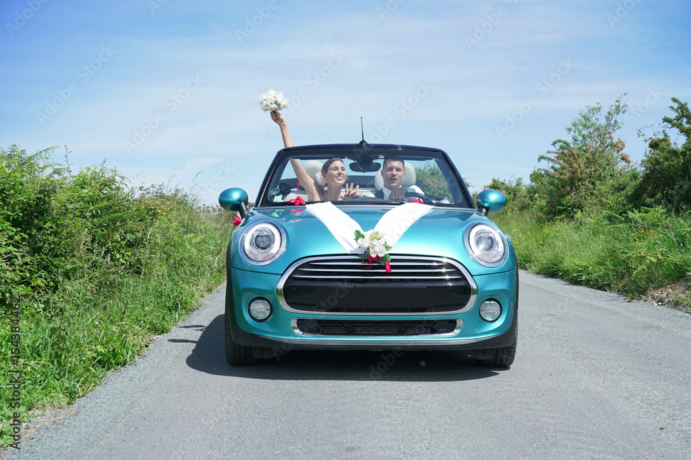 Fototapeta premium Just married couple driving convertible car