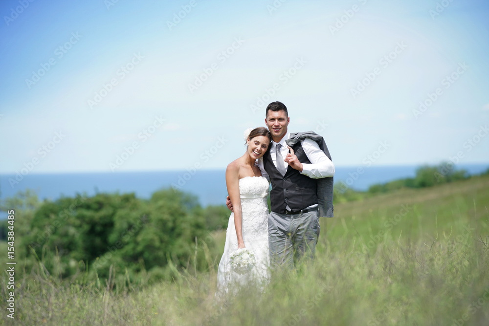 Bride and groom walking on hill