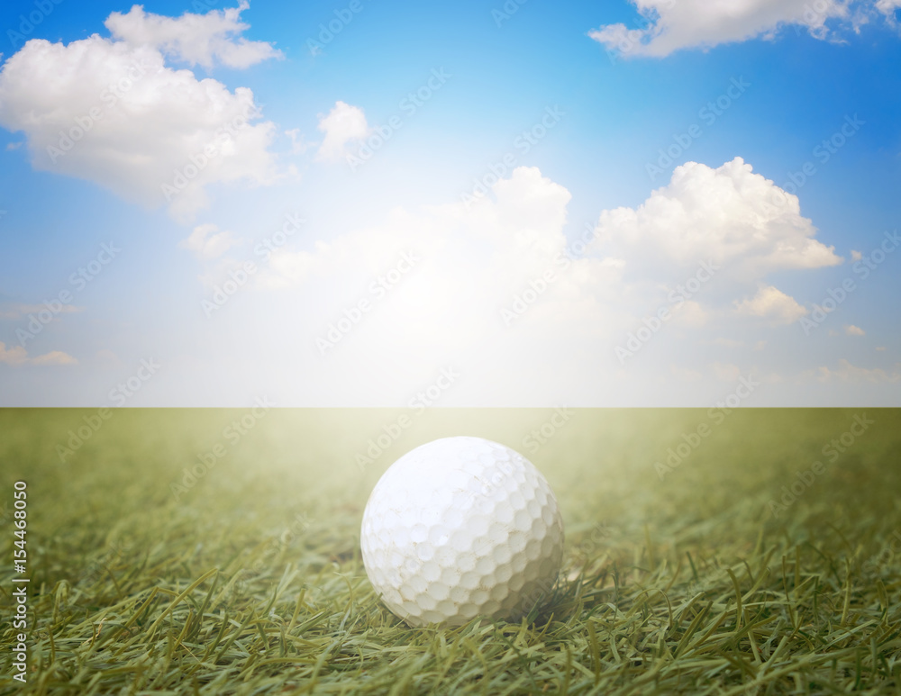 golf ball on fake green grass with sunlight and cloud blue sky background. golf ball on fake green grass with sunlight and cloud blue sky background.