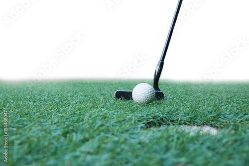 Golf ball on green field with putter and golf hole