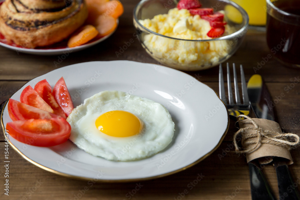 Breakfast table served with corn porridge, fried egg and juice Breakfast table served with corn porridge, fried egg and juice