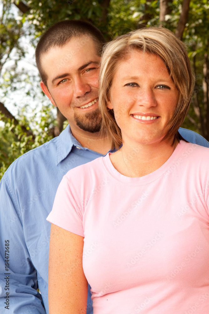 Happy couple smiling and hugging in the park. Happy couple smiling and hugging in the park.