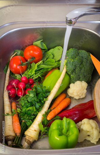 Washing fresh seasonal vegetables in the sink