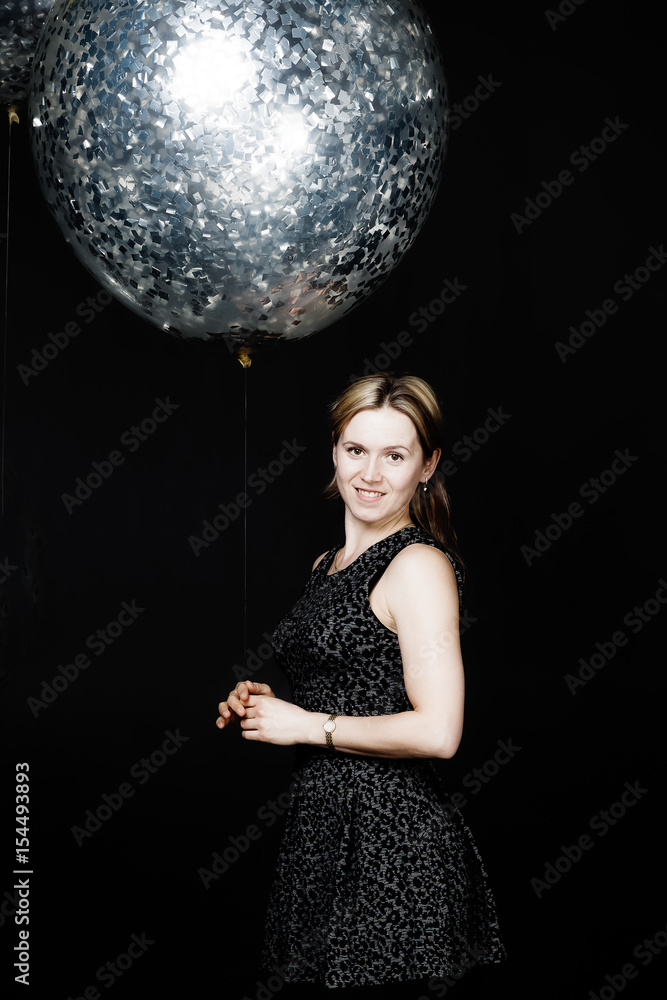 Naklejka premium The woman is standing with silver balloon