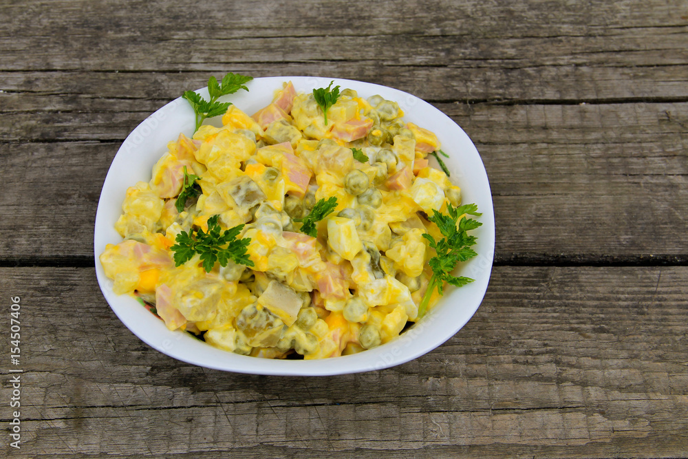 Russian traditional salad olivier on wooden table Russian traditional salad olivier on wooden table