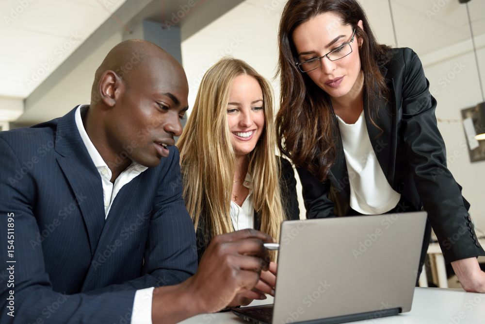 Multi-ethnic group of three businesspeople meeting in a modern office. Multi-ethnic group of three businesspeople meeting in a modern office.