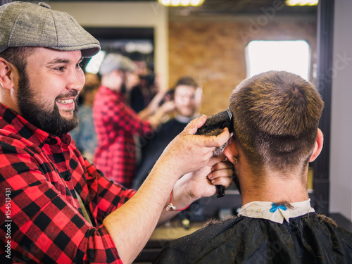 Adult male barber and customer in shop