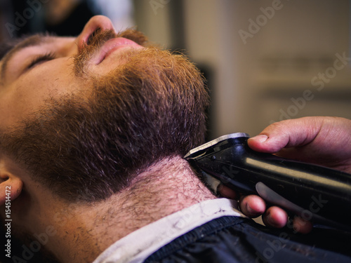 Adult male barber and customer in shop