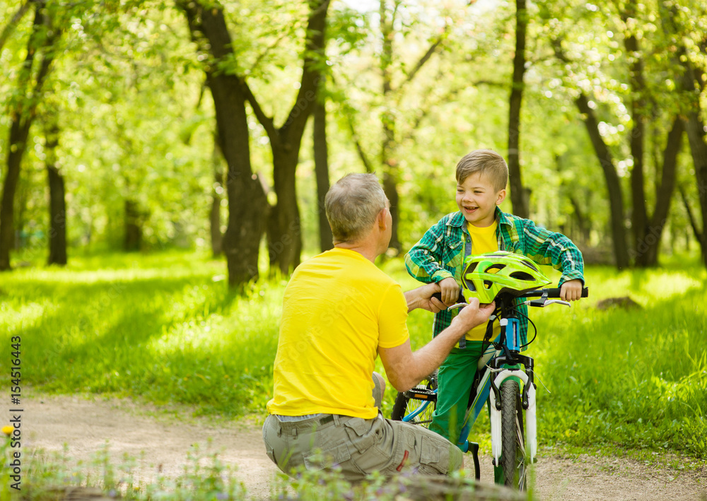 Father gives his son a bicycle helmet.