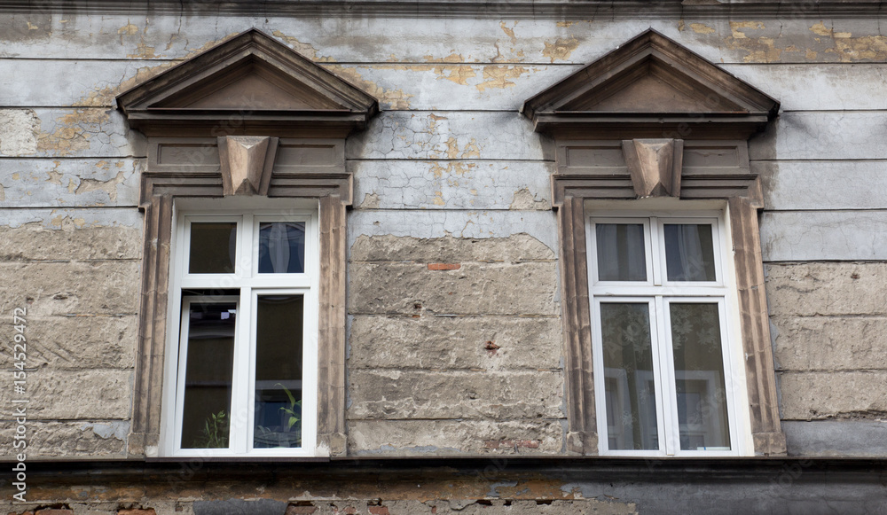 Two windows on the facade of the old ragged brick building Two windows on the facade of the old ragged brick building