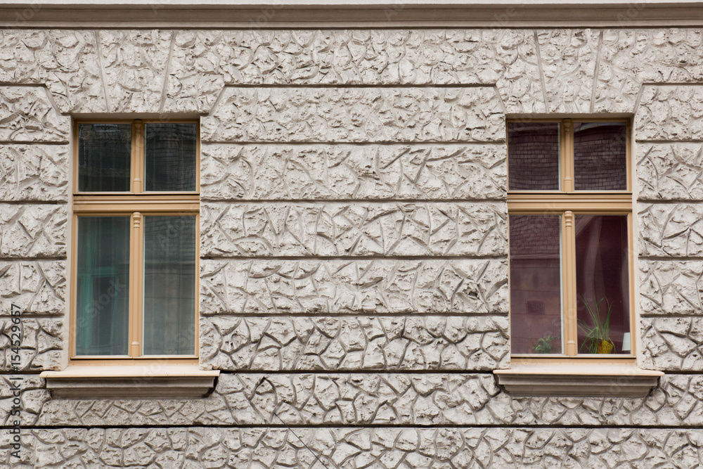 Two windows with curtains on the gray facade of the house Two windows with curtains on the gray facade of the house