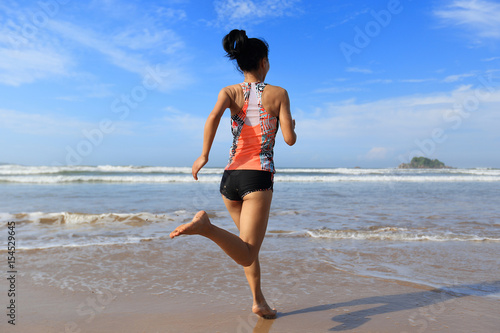 young fitness woman wear swimsuit running to the sea