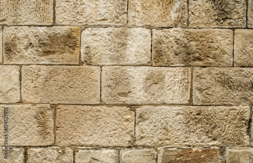 Old sandstone blocks stonewall closeup as background