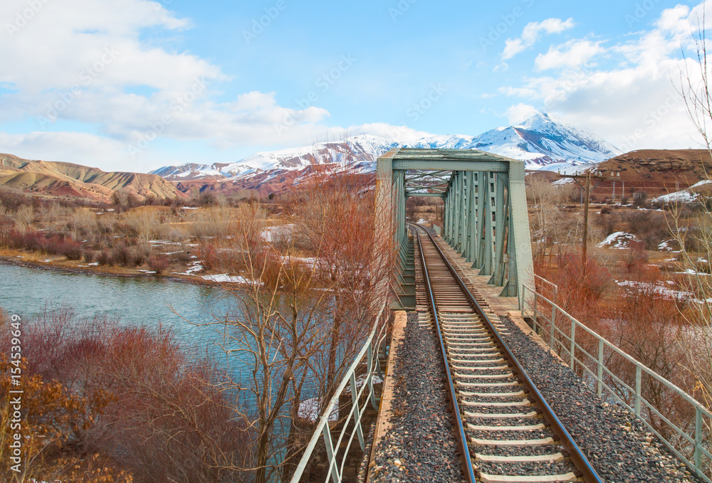 Railway bridge against white mountains Railway bridge against white mountains