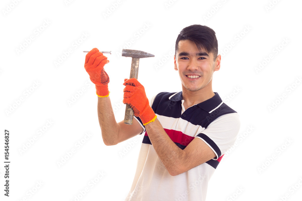 Man in orange gloves holding hammer and nail Man in orange gloves holding hammer and nail