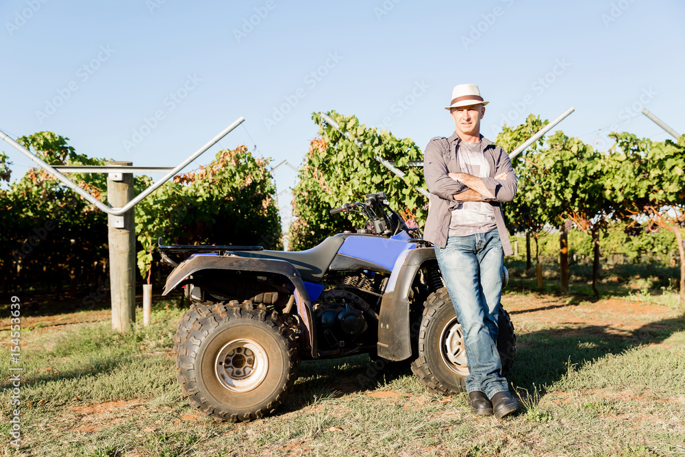 Obraz premium Man standing next to truck in vineyard
