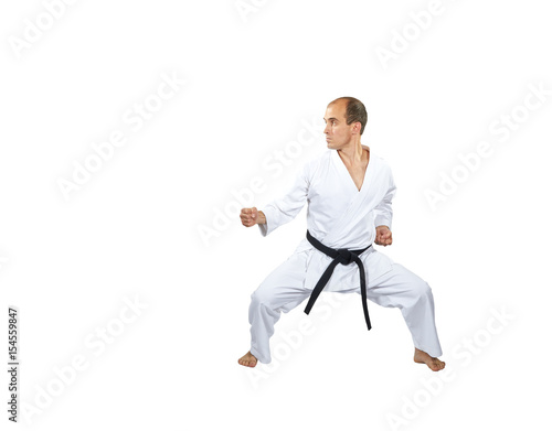 In a low karate stand, an athlete trains a punch