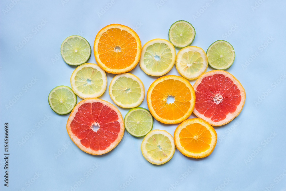 Grapefruit, orange, lemon and lime on the blue background, top view Grapefruit, orange, lemon and lime on the blue background, top view