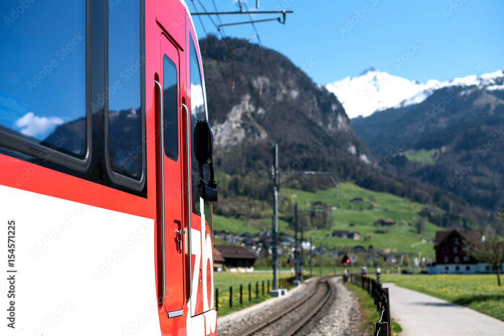 Obraz premium Red train and hills. Swiss Alps
