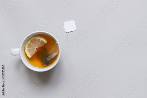 Tea time. Cup of hot black tea on the blue background, top view