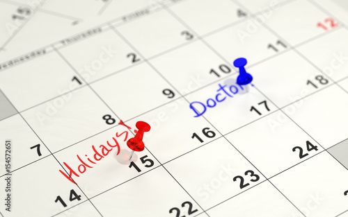 Red and blue pins marking the important days on a calendar