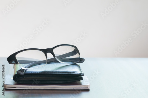 The glasses and wallet and passport isolated on the wooded table