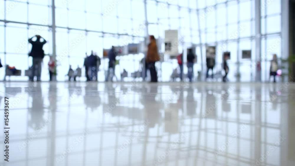 People walk inside a bright, modern building People walk inside a bright, modern building