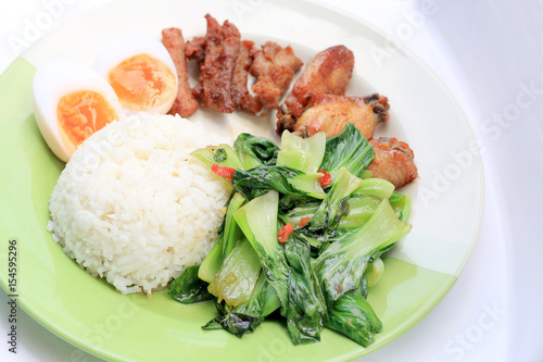 stir fried vegetables, Hard-boiled egg, Fried pork and Fried chicken wings with thai jasmine rice on dish. Thai food. photo