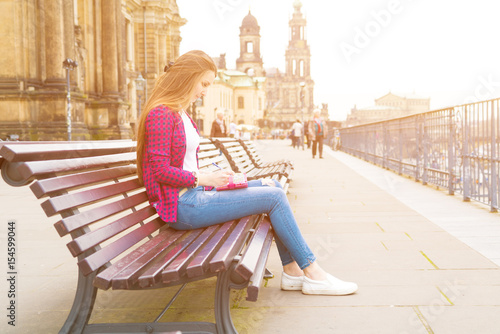 Photography girl writes in the diary the impression of the tourist on Dresden
