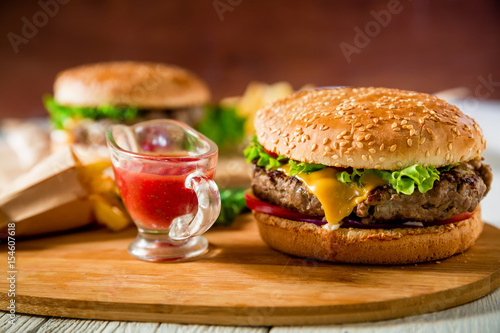 Classic hamburger with beef and tomato sauce on wooden plate. Tasty food concept