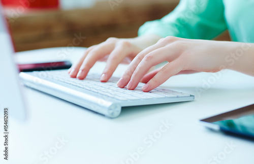 Female office worker typing on the keyboard.