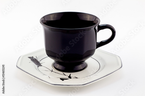 Black retro teacup on white saucer with black rose isolated on white background - English tea photo