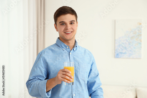 Young man drinking juice at...