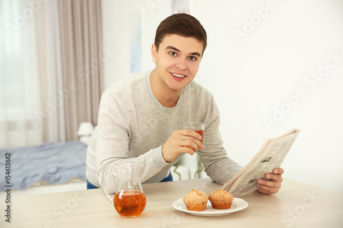 Young man drinking juice at...