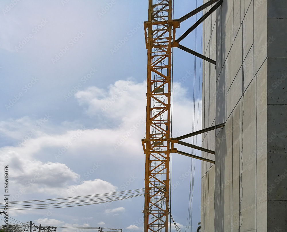 Construction cranes machine against sky background. Under construction of high-rise residential building.