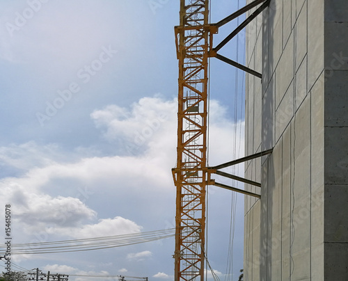 Construction cranes machine against sky background. Under construction of high-rise residential building.