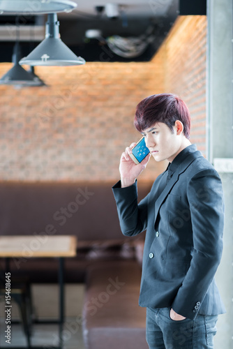 Handsome businessman in suitspeaking on the phone in coffee shop