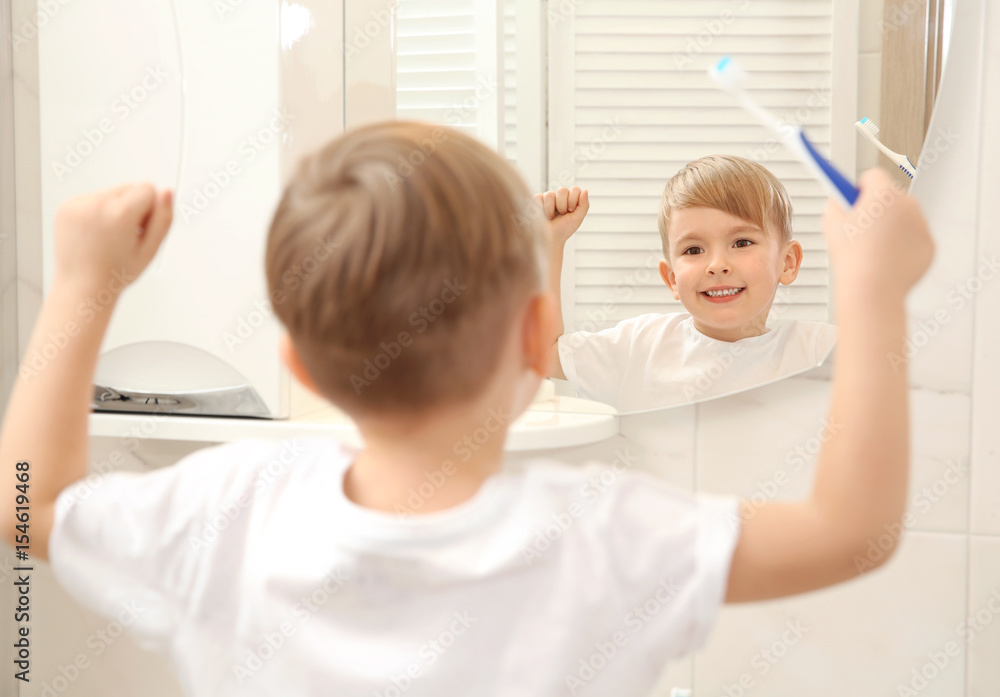 Cute little boy brushing teeth and looking in mirror Cute little boy brushing teeth and looking in mirror