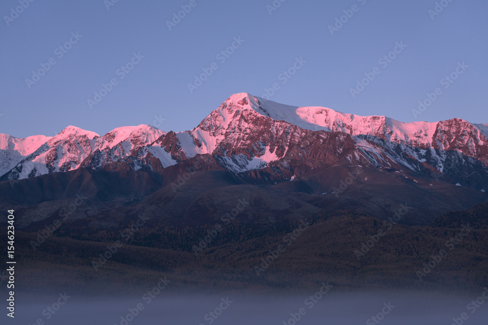 Tops of mountains sparkling by rising sun