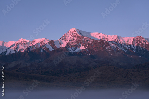 Tops of mountains sparkling by rising sun