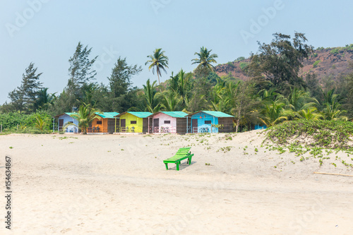 Palolym beach, colorful bungalows on the sea on the background of coconut palms, Goa, India.