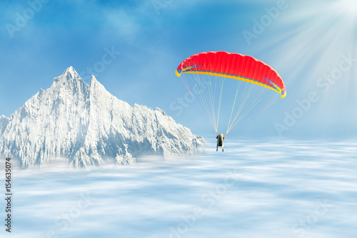 Freestyle solo paragliding over clouds against mountain peak