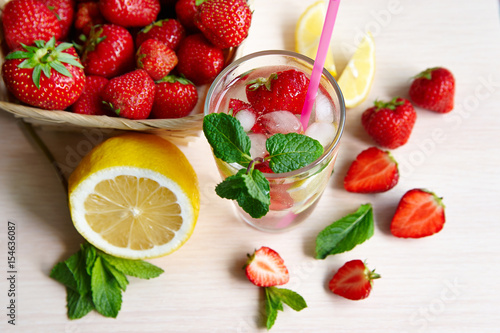 Still life of strawberries, lemon, cold drink with mint